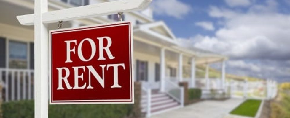 Red For Rent Real Estate Sign in Front of Beautiful House.