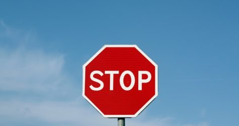 Stop sign against cloudy sky.