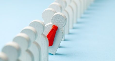 Staff recruitment. Headhunting. Many employees and the choice of a leader from the crowd. HR. A lot of white businessman and one in a red tie on a blue background